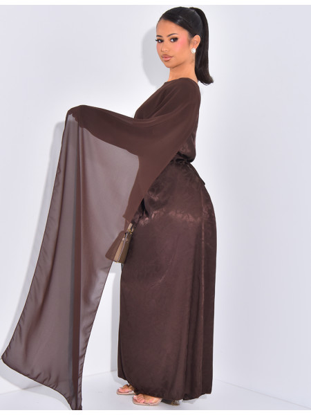 Langes, gemustertes Kleid, das im Rücken tailliert ist und an den Schultern ein Cape hat.