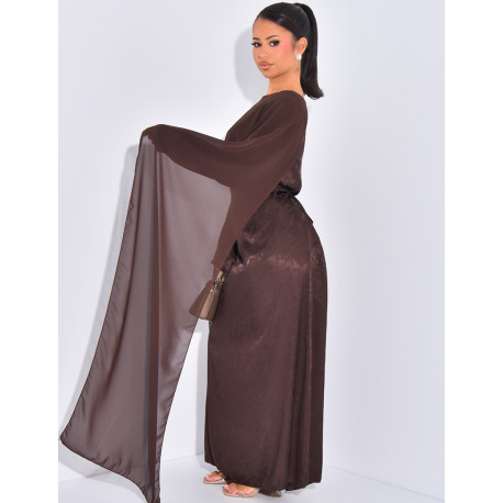 Langes, gemustertes Kleid, das im Rücken tailliert ist und an den Schultern ein Cape hat.