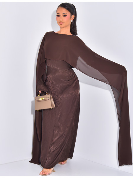 Langes, gemustertes Kleid, das im Rücken tailliert ist und an den Schultern ein Cape hat.