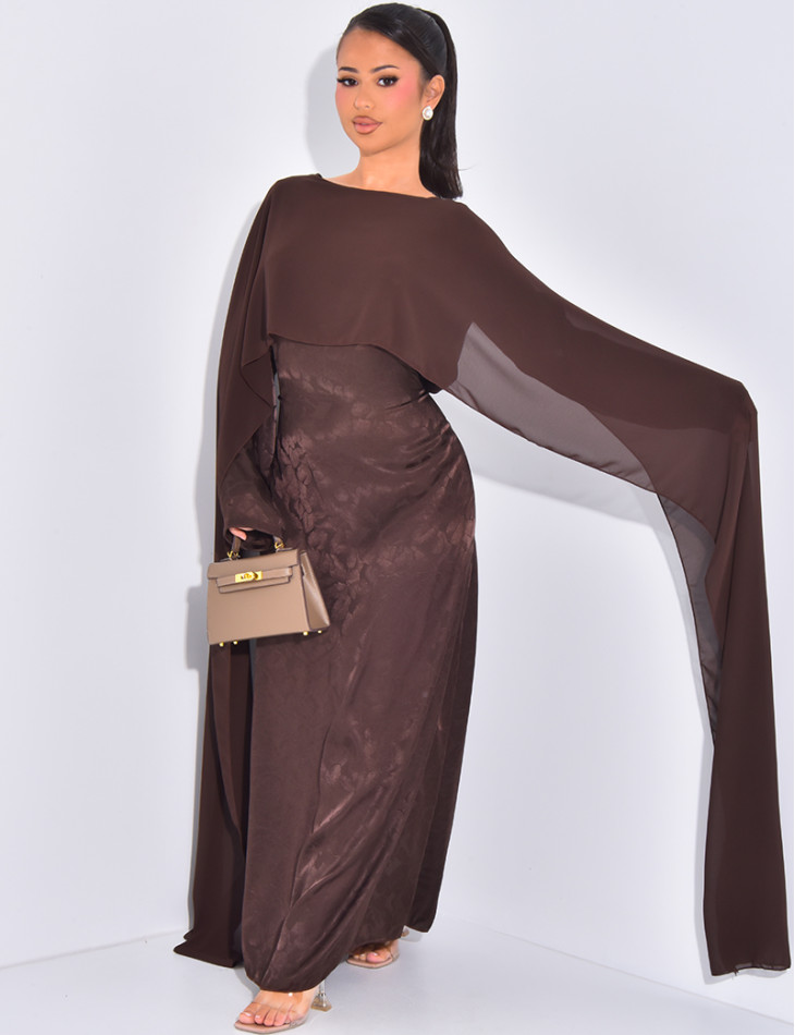 Langes, gemustertes Kleid, das im Rücken tailliert ist und an den Schultern ein Cape hat.