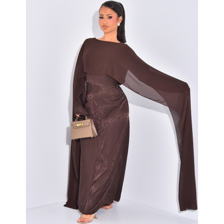 Langes, gemustertes Kleid, das im Rücken tailliert ist und an den Schultern ein Cape hat.