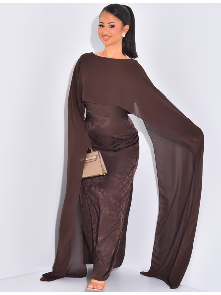 Langes, gemustertes Kleid, das im Rücken tailliert ist und an den Schultern ein Cape hat.