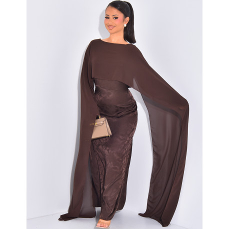 Langes, gemustertes Kleid, das im Rücken tailliert ist und an den Schultern ein Cape hat.