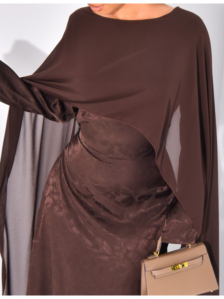 Langes, gemustertes Kleid, das im Rücken tailliert ist und an den Schultern ein Cape hat.