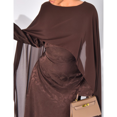 Langes, gemustertes Kleid, das im Rücken tailliert ist und an den Schultern ein Cape hat.